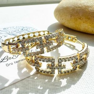 Aretes de aro con forma encadenada abrillantados en zirconia. Tamaño mediano.